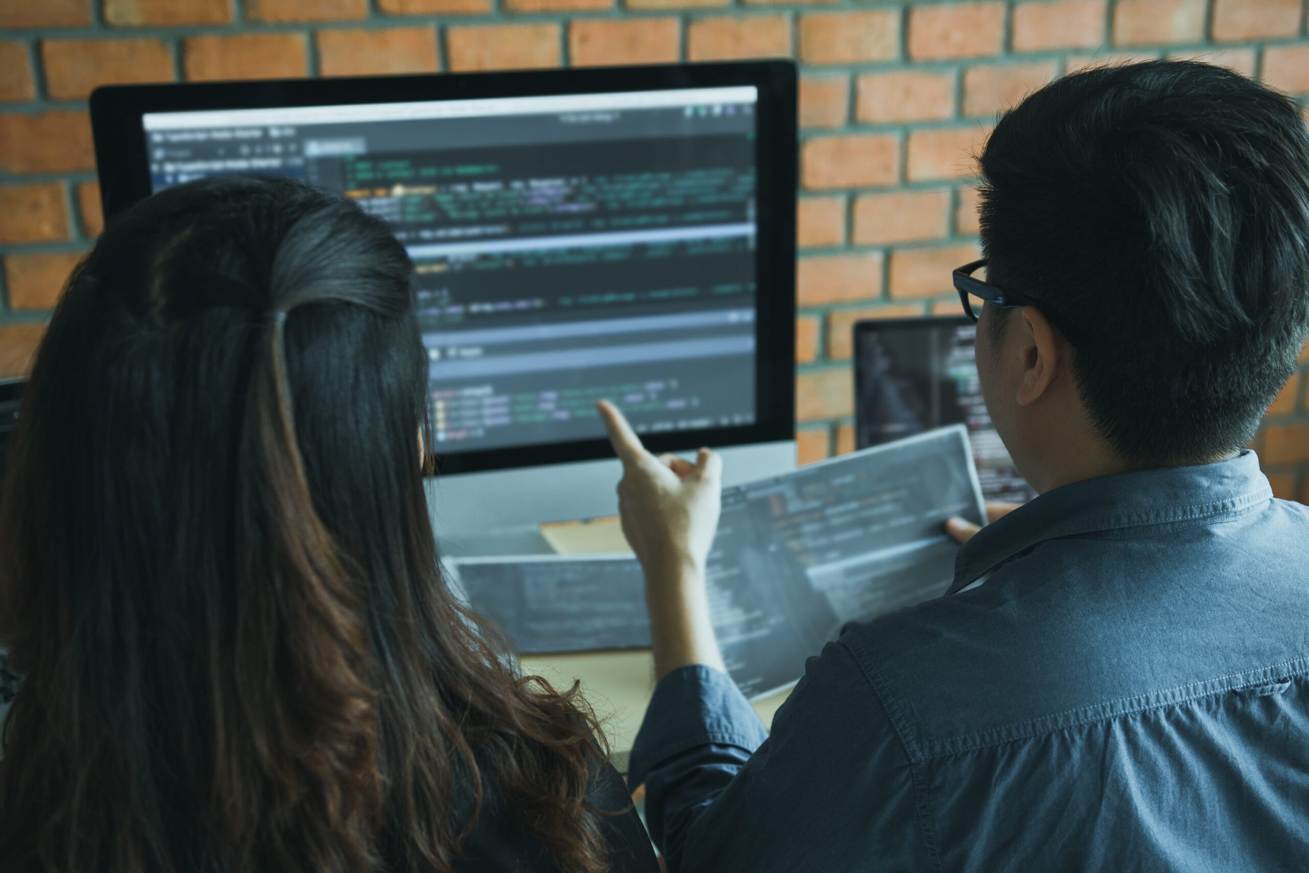 Two Software Developers Are Using Computers To Work Together Wit