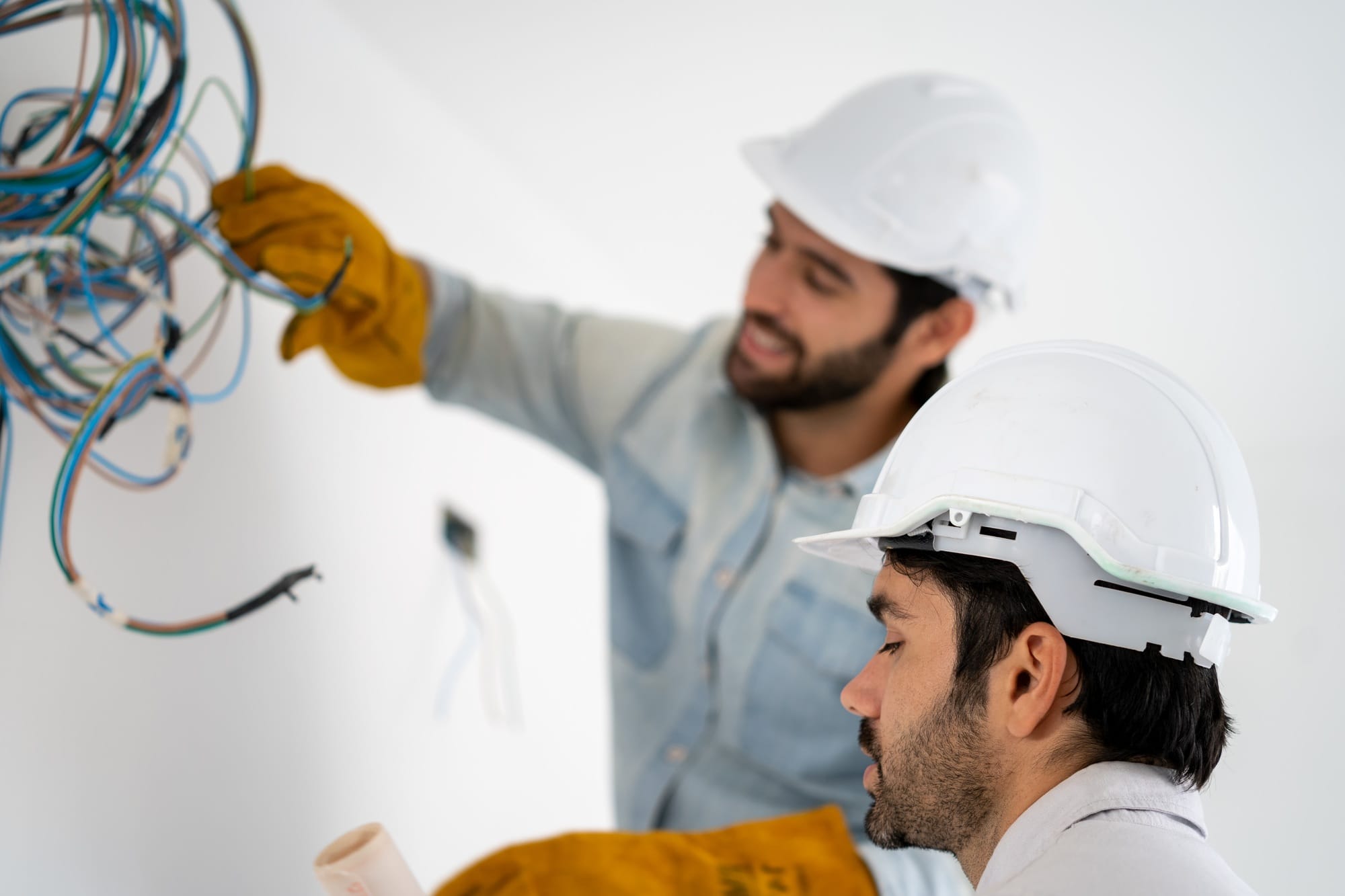 Electrician mounting wiring for electric sockets on the construction site of a new house.