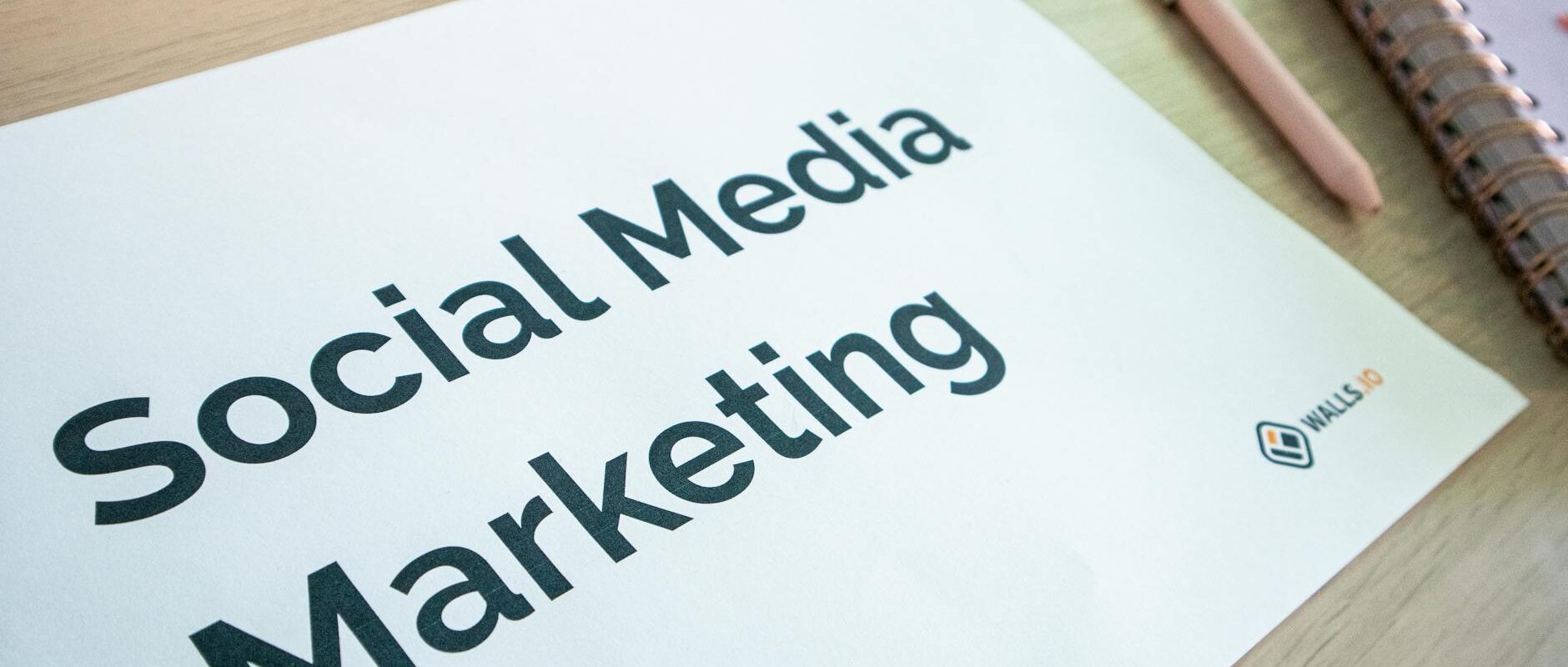 Close-up of a social media marketing document on a desk with a pen and notebook.