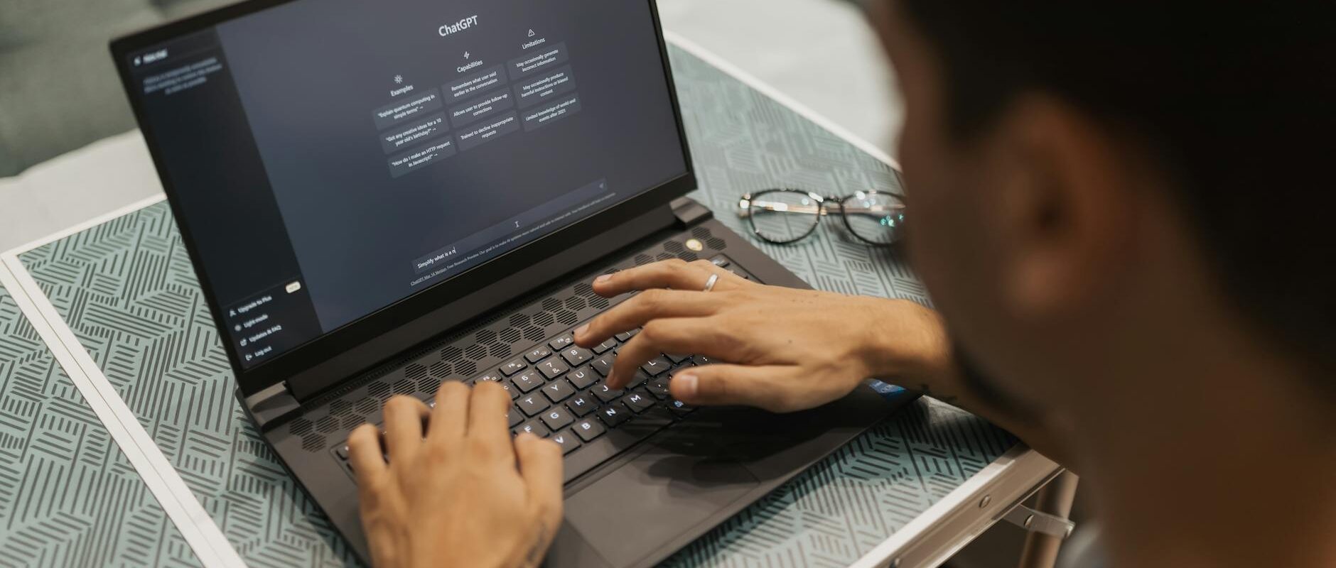 A person using a laptop to interact with AI technology indoors during the day.