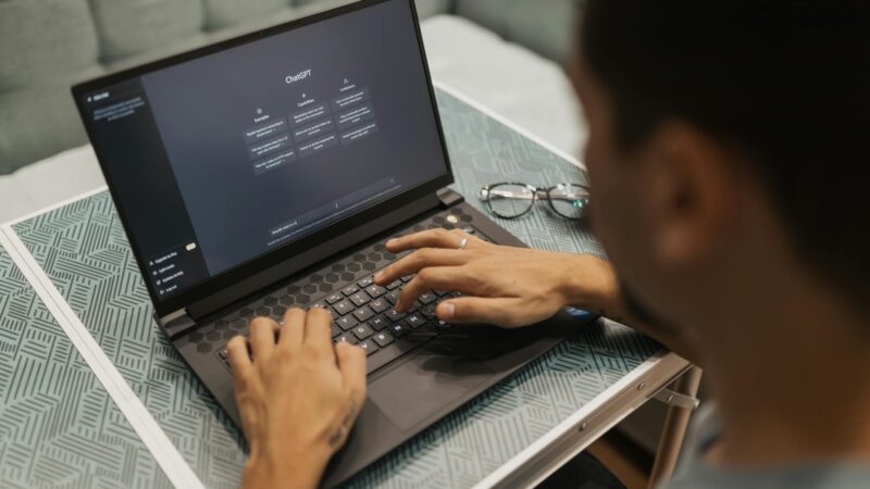 A person using a laptop to interact with AI technology indoors during the day.