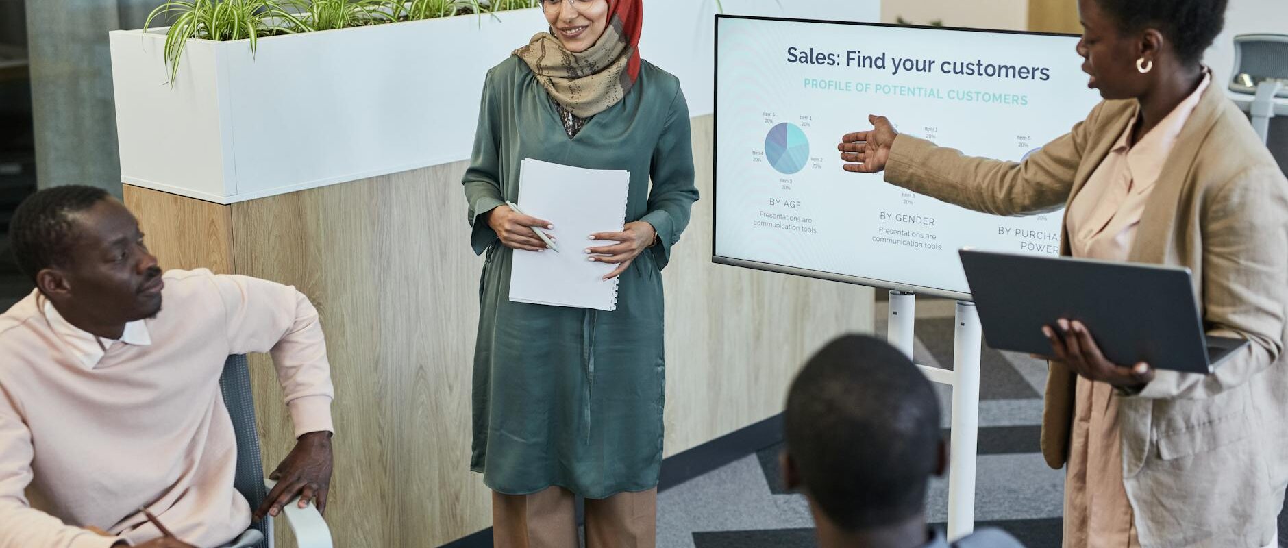 Team of professionals discussing sales strategy during a business presentation in a modern office.
