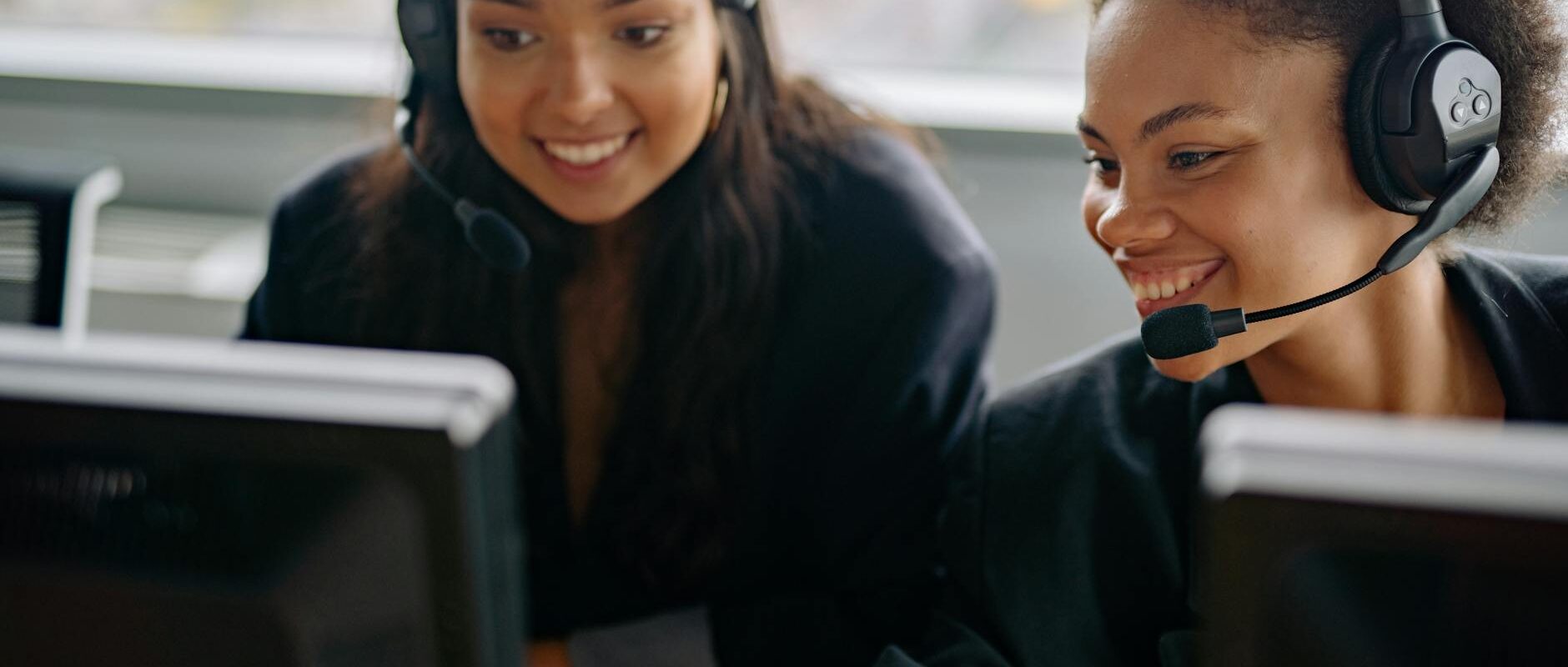 Two cheerful call center agents at work, engaging with customers and providing support.