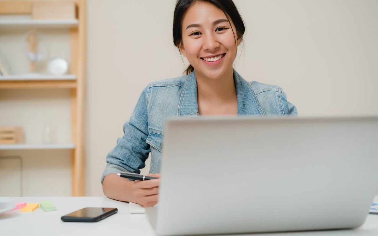 Filipino virtual assistant managing social media happily on laptop