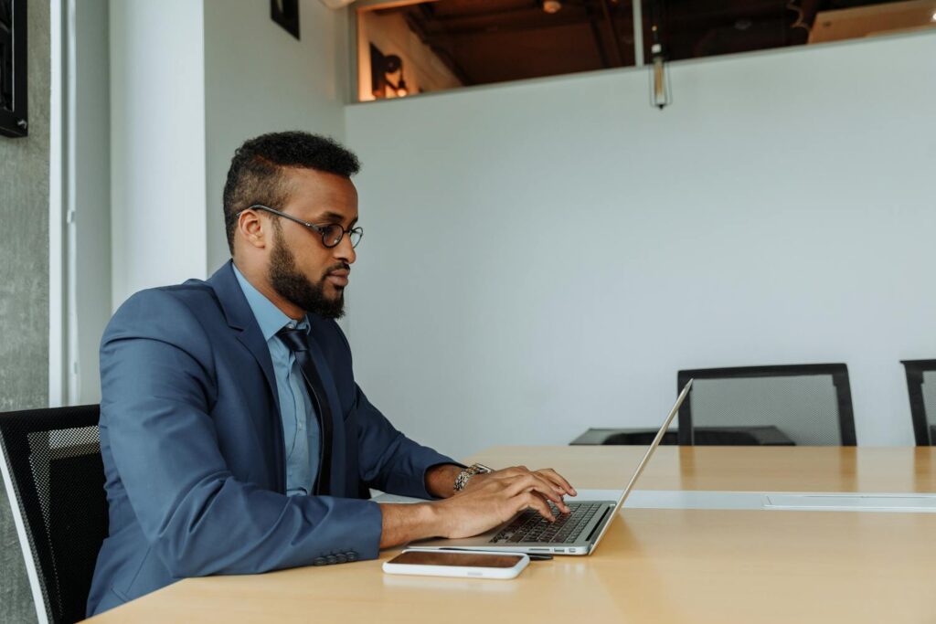 Focused businessman working on laptop — Filipino virtual assistant supporting US business