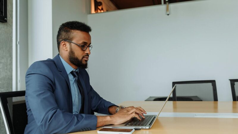 Focused businessman working on laptop — Filipino virtual assistant supporting US business