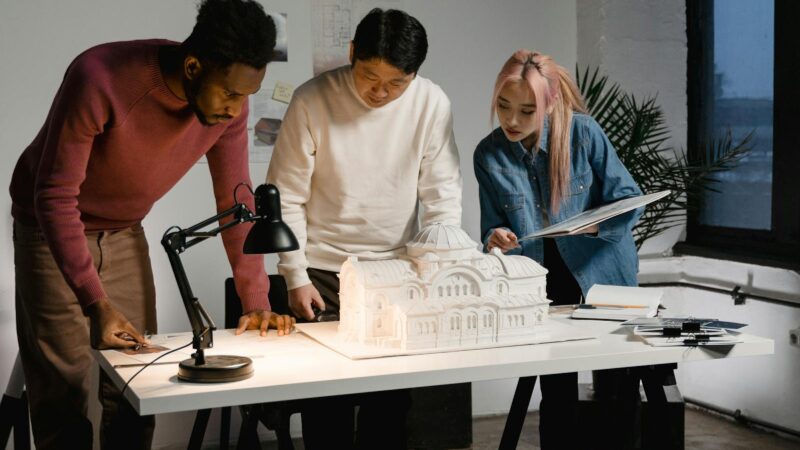 Diverse team collaborating on architectural project with scale model