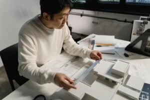Architect examining architectural scale model with precision tools