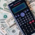 Calculator on top of NZ dollar bills representing virtual assistant cost calculation