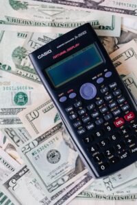 Calculator on top of NZ dollar bills representing virtual assistant cost calculation