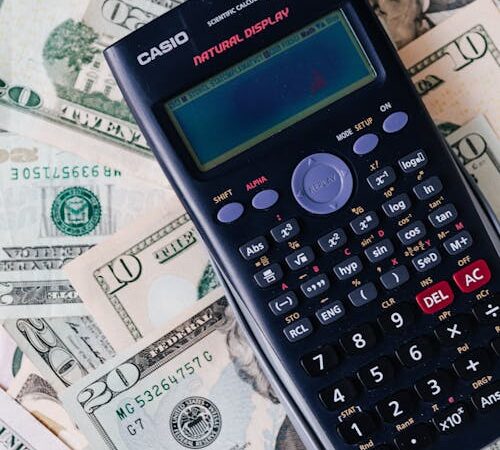 Calculator on top of NZ dollar bills representing virtual assistant cost calculation