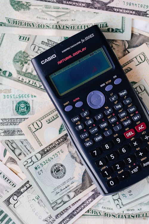 Calculator on top of NZ dollar bills representing virtual assistant cost calculation
