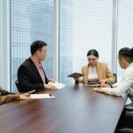 Diverse team of professionals comparing options in a boardroom meeting