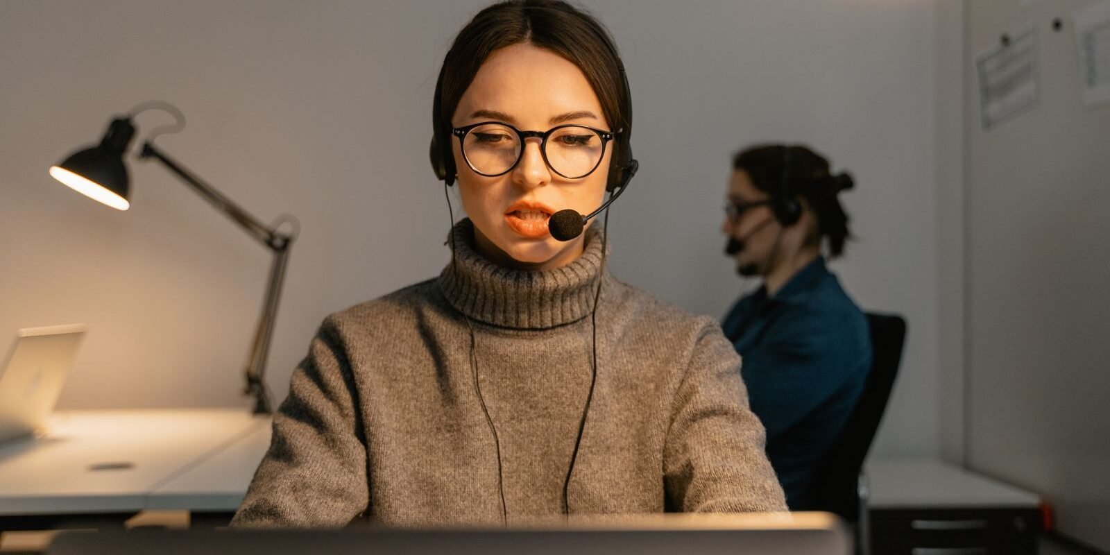 Receptionist wearing a headset answering calls after hours