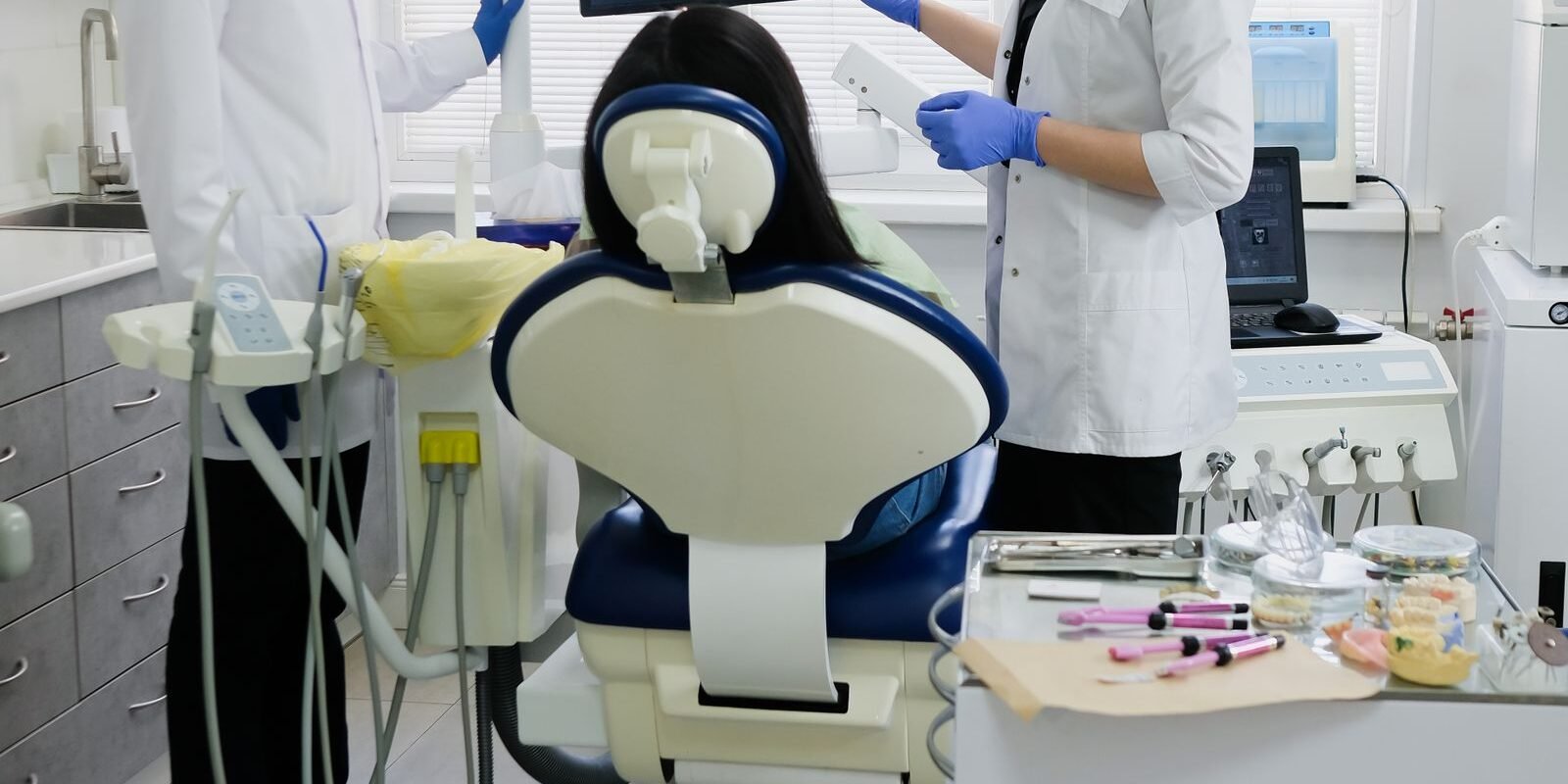 Dental team treating a patient in a modern clinic operatory