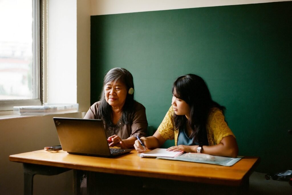 An Arma ramp mentor coaching a new virtual assistant at a laptop