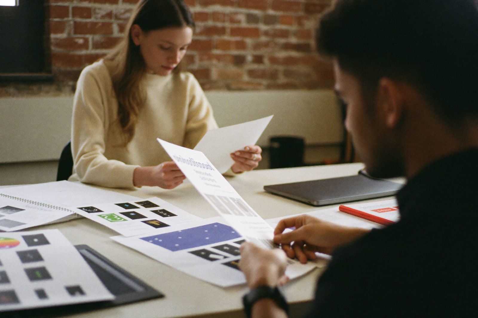 Two agency founders comparing printed vendor comparison sheets