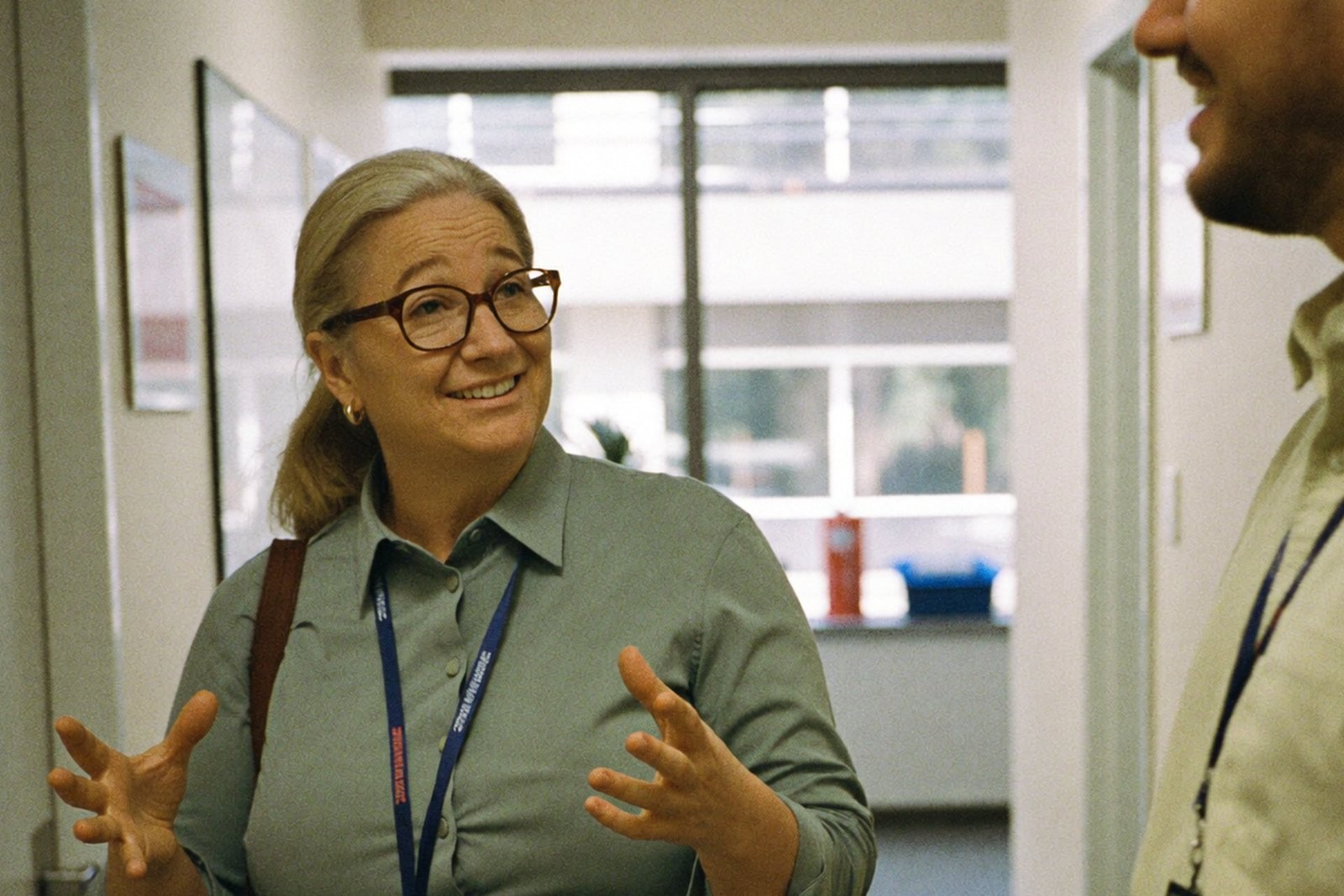 Property manager and colleague comparing vendor options in a bright rental office hallway