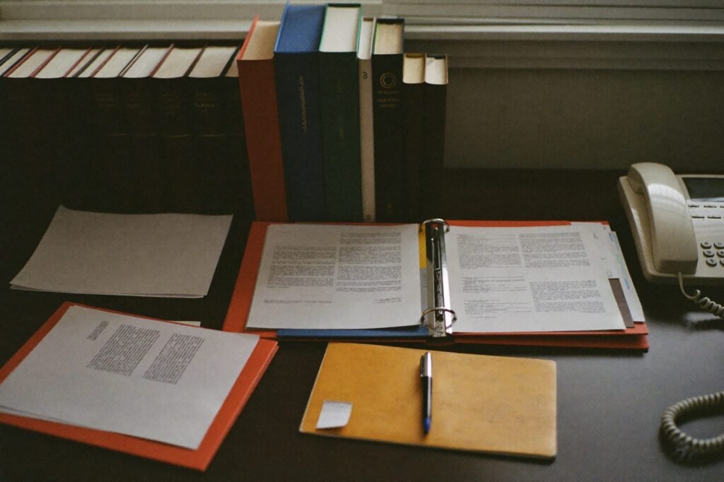 Law firm desk with legal folders, law books, and a desk phone
