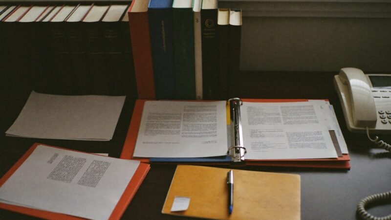 Law firm desk with legal folders, law books, and a desk phone