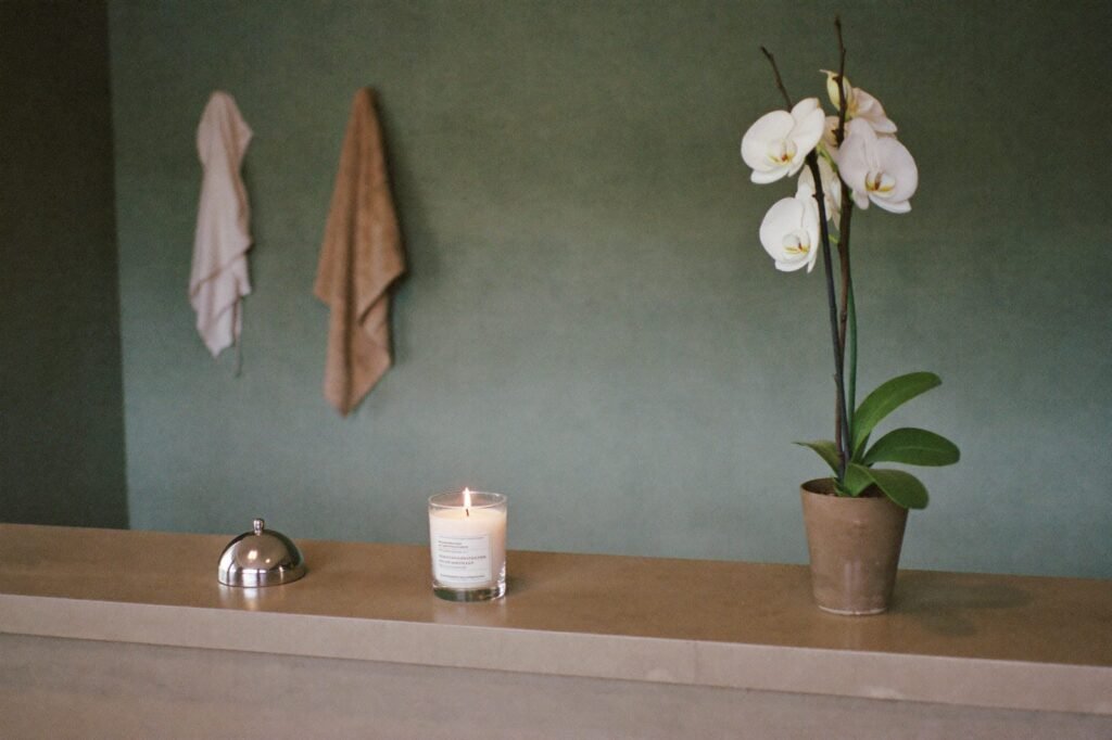 Medical spa reception counter with an orchid, a call bell, and a lit candle