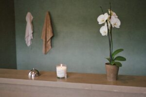 Medical spa reception counter with an orchid, a call bell, and a lit candle