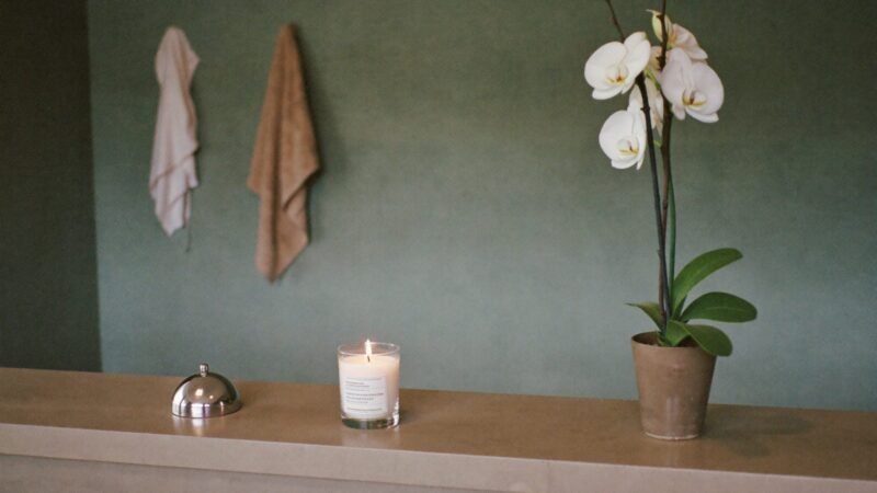 Medical spa reception counter with an orchid, a call bell, and a lit candle