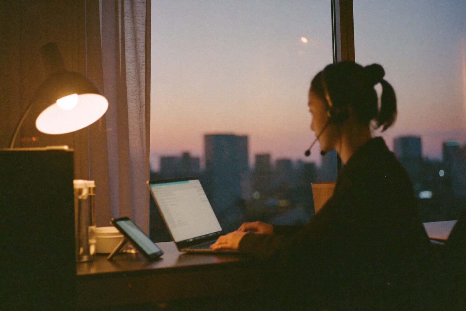 Remote short-term rental virtual assistant answering guest messages at dusk