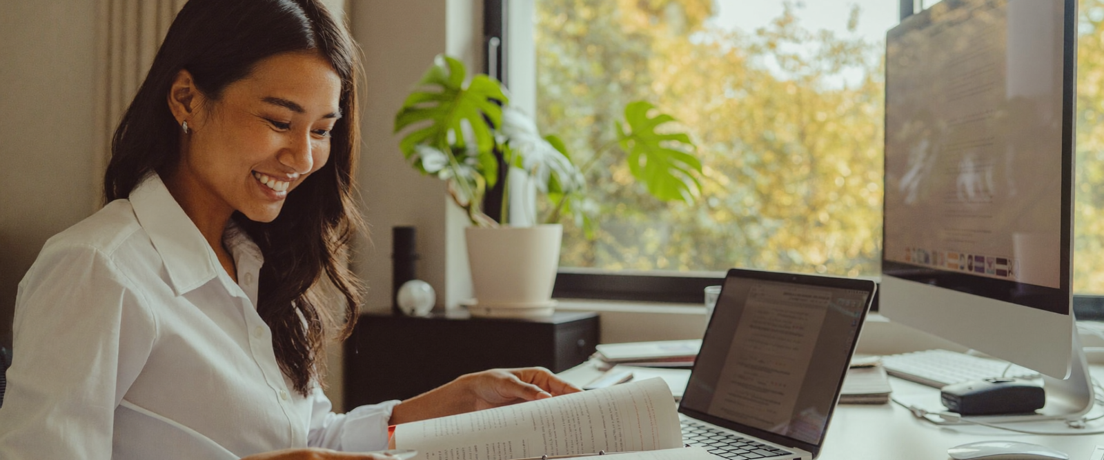 Filipina HR virtual assistant reviewing paperwork at a bright desk