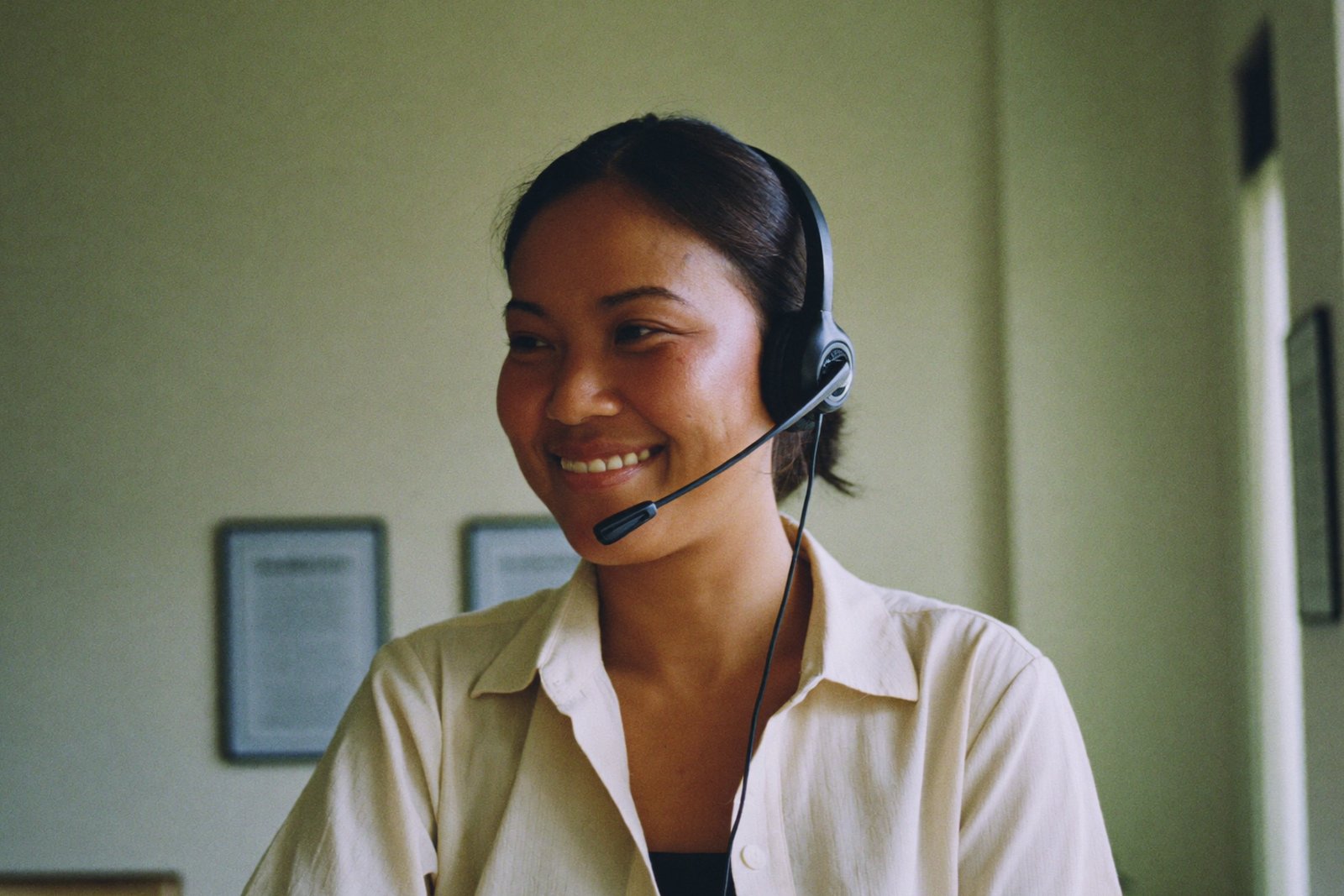 Filipina virtual receptionist wearing a headset answering a small business call